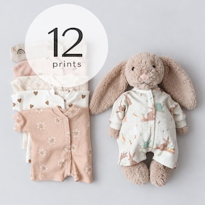 Könnte beinhalten: Ein Stapel Baby-Strampler mit 12 Drucken und ein Plüsch-Hase, der einen passenden Strampler mit Hasen-, Karotten- und Gießkannenmuster trägt. Die Strampler zeigen verschiedene Farben und Designs wie Blumen, Herzen und Regenbögen.