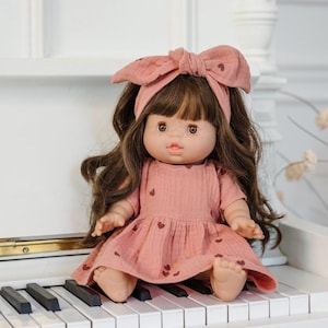 A Paola Reina doll dress for Minikane gordis doll - old rose with dark heart patterns and a matching headband.