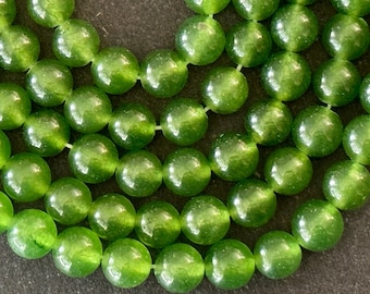 Op de afbeelding: Een streng groene jade kralen, elke kraal is rond en glad met een glanzende afwerking.