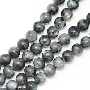 May include: A strand of round, black labradorite gemstone beads. The beads are smooth and have a slight shimmer.