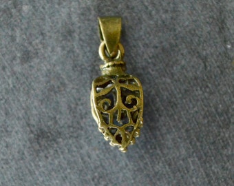 Pode incluir: Um pingente de metal dourado em forma de coração com um design intrincado e vazado. O pingente tem um laço na parte superior para prender a uma corrente.