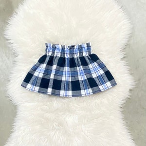 May include: A blue and white plaid skirt with a gathered elastic waistband.