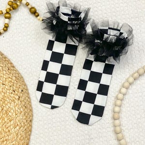 May include: A white ceramic mug with a black handle and the text "But First, Coffee" in a black, bold font. The mug is on a white surface.