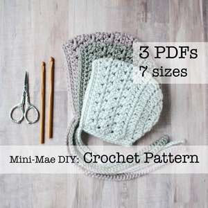 May include: A crochet baby bonnet pattern in three different colors, with a pair of crochet hooks and a pair of scissors. The pattern is available in seven sizes and includes three PDFs. The text on the image reads "3 PDFs 7 sizes Mini-Mae DIY: Crochet Pattern".