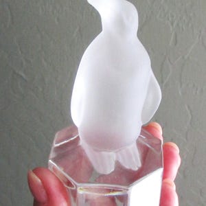 May include: A set of three ceramic mugs with a speckled, cream-colored glaze. Each mug features a different hand-painted floral design in shades of blue, green, and yellow. The mugs have a simple, rounded shape and a comfortable handle.