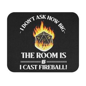 May include: Black square mousepad with the text "I DON'T ASK HOW BIG - THE ROOM IS I CAST FIREBALL!" A flaming 20-sided die is in the center. The die has the number 20 visible.