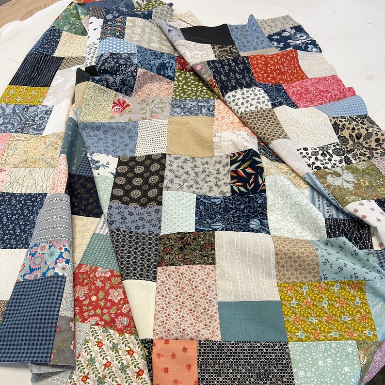 scrappy patchwork quilt handmade multi color blue green pink orange yellow black and white. floral and geometric prints. all soft cotton fabrics