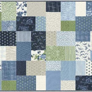 May include: A patchwork quilt featuring a variety of rectangular fabric blocks in shades of navy blue, light blue, sage green, and cream. The design includes diverse patterns such as floral prints, thin stripes, cross-hatch lines, and solid colors.