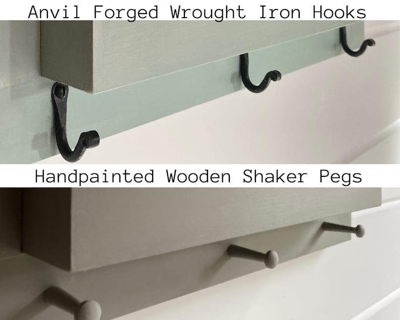 May include: A wooden shelf with the text "Anvil Forged Wrought Iron Hooks" and "Handpainted Wooden Shaker Pegs" on it. The shelf has three black metal hooks and two wooden pegs.