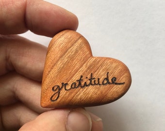 Corazón de bolsillo: un corazón de madera de cerezo tallado a mano; grabado a mano con la palabra o fecha elegida. Un talismán para uso diario. Un regalo de amor.