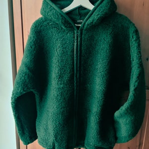 May include: A dark green hooded fleece jacket with a zip closure.