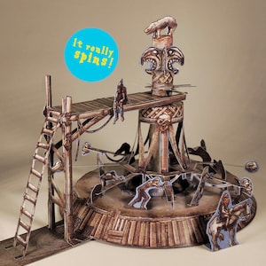 May include: A brown papercraft carousel with a ladder, figures, and the text "It really spins!" A bear and carved faces top the structure. Figures appear to be riding the carousel.