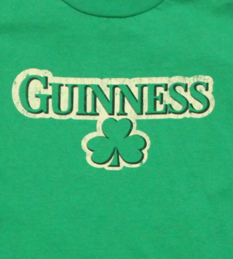 May include: Green t-shirt with a white vintage-style "GUINNESS" logo and a green shamrock.