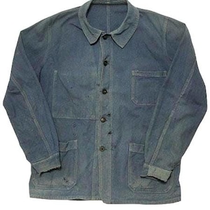 May include: A long-sleeve blue denim chore jacket featuring a classic collar, a front button-down closure with dark buttons, one chest pocket, and two large lower patch pockets. The fabric shows signs of wear with visible fading and small holes.