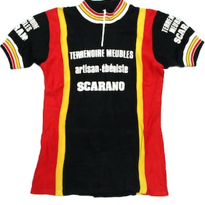 May include: Black cycling jersey with red and yellow stripes. The jersey has the text "TERRENOIRE MEUBLES artisan-ébéniste SCARANO" printed on the front.