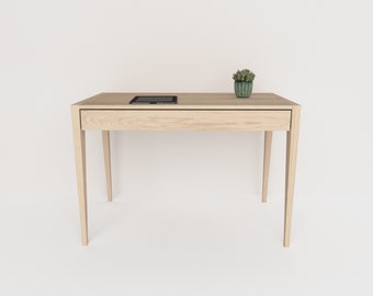 May include: A light wood desk with a single drawer and a tablet computer on top. A small potted succulent plant sits on the desk.