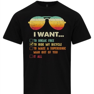 Könnte beinhalten: Ein schwarzes Kurzarm-T-Shirt mit einer Grafik von Retro-Fliegerbrillen über dem Text I WANT... und einer Checkliste mit den Optionen TO BREAK FREE, TO RIDE MY BICYCLE, TO MAKE A SUPERSONIC MAN OUT OF YOU und IT ALL.