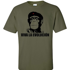 May include: A green t-shirt featuring a black silhouette of a monkey wearing a red star beret. The text "VIVA LA EVOLUCIÓN" is printed below the monkey.