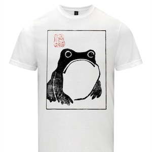 May include: White t-shirt featuring a black and white image of a frog and a red stamp with Japanese characters.