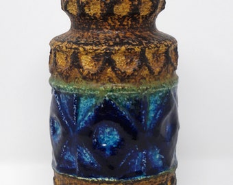 May include: A brown and blue ceramic vase with a textured surface and geometric patterns. The vase has a wide mouth and a narrow base.