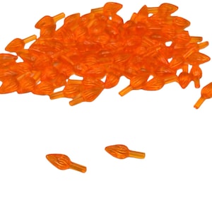 May include: A pile of orange plastic Christmas tree light bulb tips. The tips are shaped like a flame and have a small hole at the bottom for the light bulb to fit through.