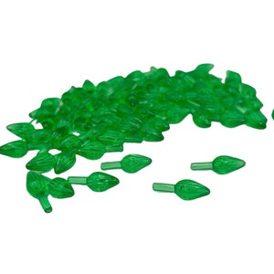 Puede incluir: Un montón grande de puntas de bombillas de luces navideñas de plástico verde. Las puntas tienen forma de lágrima y tienen un pequeño agujero en la parte inferior para que la bombilla encaje.