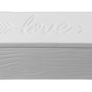 May include: White ceramic box with a woodgrain pattern on the bottom and a lid with the word "love" and arrows on either side.