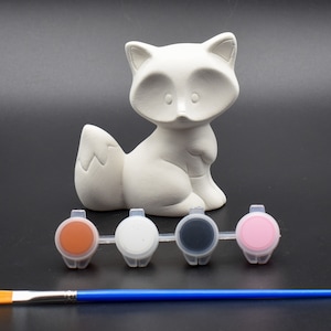 May include: White ceramic fox figurine with a paint set of brown, white, black, and pink paint and a blue paintbrush.