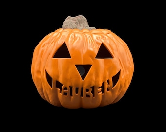 May include: Orange plastic jack-o'-lantern with a carved face and the name "Lauren" written inside.