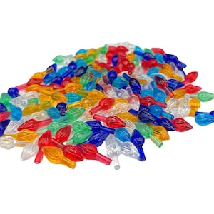 May include: A pile of colorful Christmas light bulb covers in various colors, including red, green, blue, yellow, and clear. The covers are shaped like teardrops and are made of transparent plastic.
