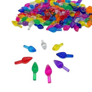 May include: Assortment of colorful plastic Christmas light bulb tips. The tips are in various colors, including red, blue, green, yellow, and purple. The tips are arranged in a circle on a white background.