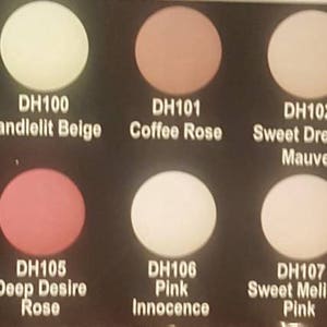 May include: A color chart with 10 different shades of pink, beige, and purple nail polish. The chart is labeled "Romance Colors" and each color has a name and a code, such as "DH100 Candlelit Beige" and "DH101 Coffee Rose".
