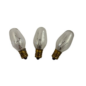 May include: Three clear glass light bulbs with a standard screw base.