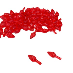 Könnte beinhalten: Ein Haufen roter Weihnachtsbaumlicht-Glühbirnenspitzen aus Kunststoff. Die Spitzen sind flammenförmig und haben einen kleinen Stiel.