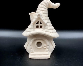 Könnte beinhalten: Weißes Keramikhaus in Form eines Hexenhutes mit Schornstein, Fenster und Tür. Das Haus ist bereit zum Bemalen.
