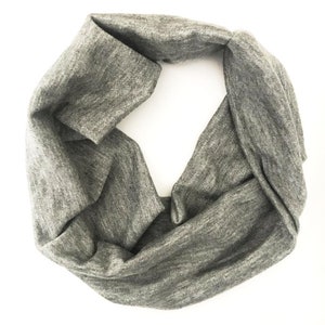 Puede incluir: Un pa&ntilde;uelo infinito gris hecho de tela suave y texturizada. El pa&ntilde;uelo est&aacute; doblado en forma de ocho, creando un bucle continuo. El color neutro y el dise&ntilde;o sencillo lo convierten en un accesorio vers&aacute;til para varios atuendos.