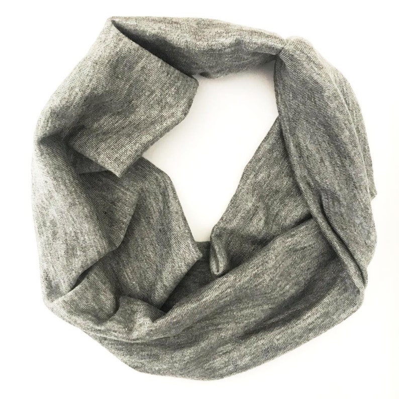 Puede incluir: Un pa&ntilde;uelo infinito gris hecho de tela suave y texturizada. El pa&ntilde;uelo est&aacute; doblado en forma de ocho, creando un bucle continuo. El color neutro y el dise&ntilde;o sencillo lo convierten en un accesorio vers&aacute;til para varios atuendos.