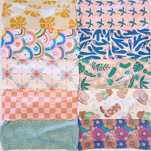 May include: Set of ten fabric headbands with different patterns. The patterns include a floral design, a chequered pattern, a rainbow pattern, a palm tree pattern, a smiley face pattern, and more. The headbands are all in pastel colours.