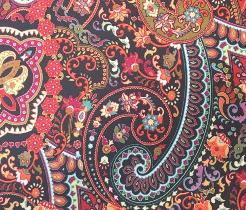 May include: A black fabric with a paisley pattern in shades of red, orange, yellow, green, blue, and purple. The pattern is intricate and detailed, with a variety of shapes and sizes.