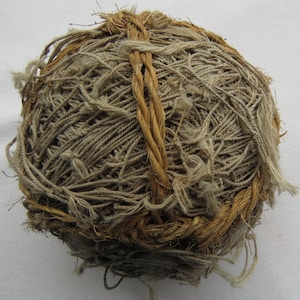 Puede incluir: Una bola de hilo marrón envuelta en un cordón grueso marrón.