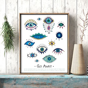 May include: A framed art print featuring various stylized eye illustrations in blue, yellow, and pink on a white background. The phrase "Go Away" is below the eyes, with additional text at the bottom. The frame is a warm brown color.