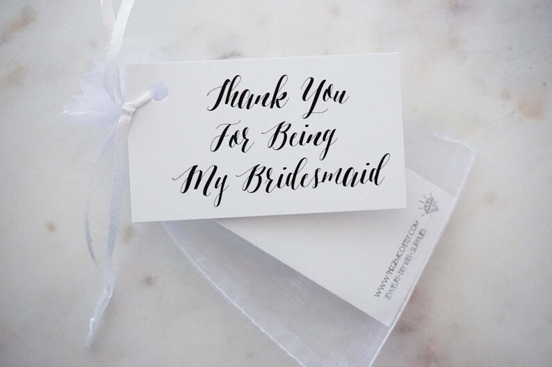 May include: White card with black calligraphy that reads "Thank You For Being My Bridesmaid".