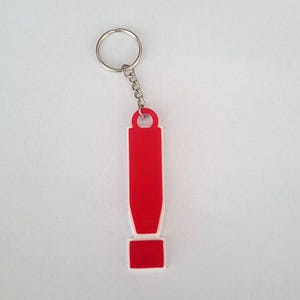 May include: A red exclamation mark keyring with a silver key ring. The keyring is made of plastic and has a white outline.