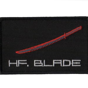 May include: Black embroidered patch with a red sword and the text "HF. BLADE" in white.