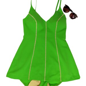 May include: A bright green swimsuit with a v-neck and thin straps. The swimsuit has white stitching along the seams.