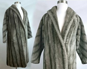 May include: A long, gray and white striped faux fur robe with a shawl collar and a tie closure.