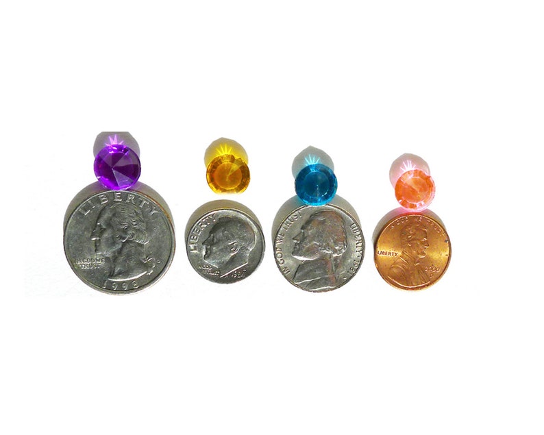 May include: Four small, round, faceted glass gems in different colors: purple, yellow, blue, and pink. The gems are placed on top of US coins to show their size.