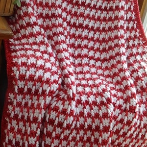 May include: Red and white crocheted throw blanket with a houndstooth pattern.