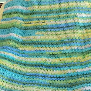 May include: A crocheted blanket with stripes of yellow, green, blue and white.