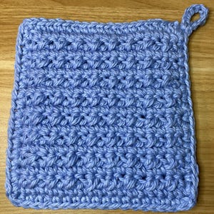 Może przedstawiać: Niebieski, szydełkowy uchwyt na garnek z pętlą.